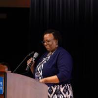 Dean of College of Education on stage behind podium